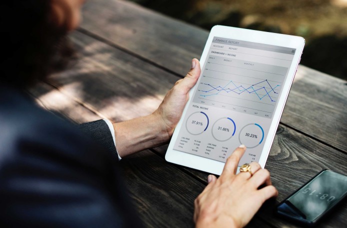Frau schaut sich Statistiken auf dem Tablet an