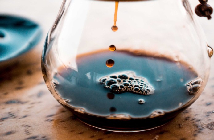 Kaffee tropft in eine gläserne Kaffeekanne.